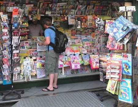 Photo of traveler next to a newsstand in a Livorno.
