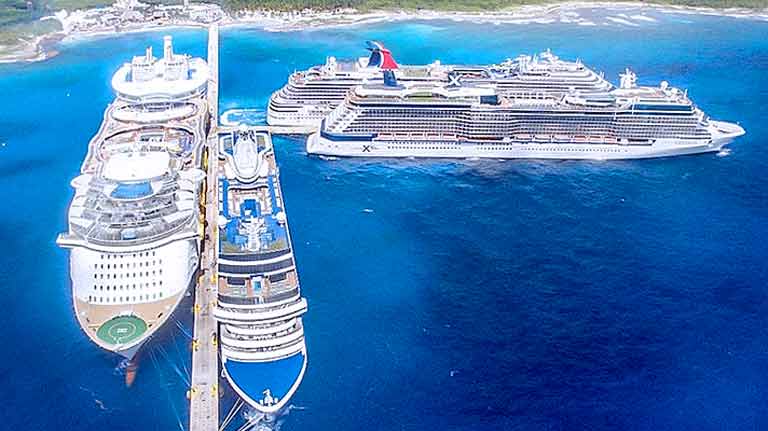 Panoramic view of 4 ships docked at the T-shaped cruise piers in Puerto Costa Maya